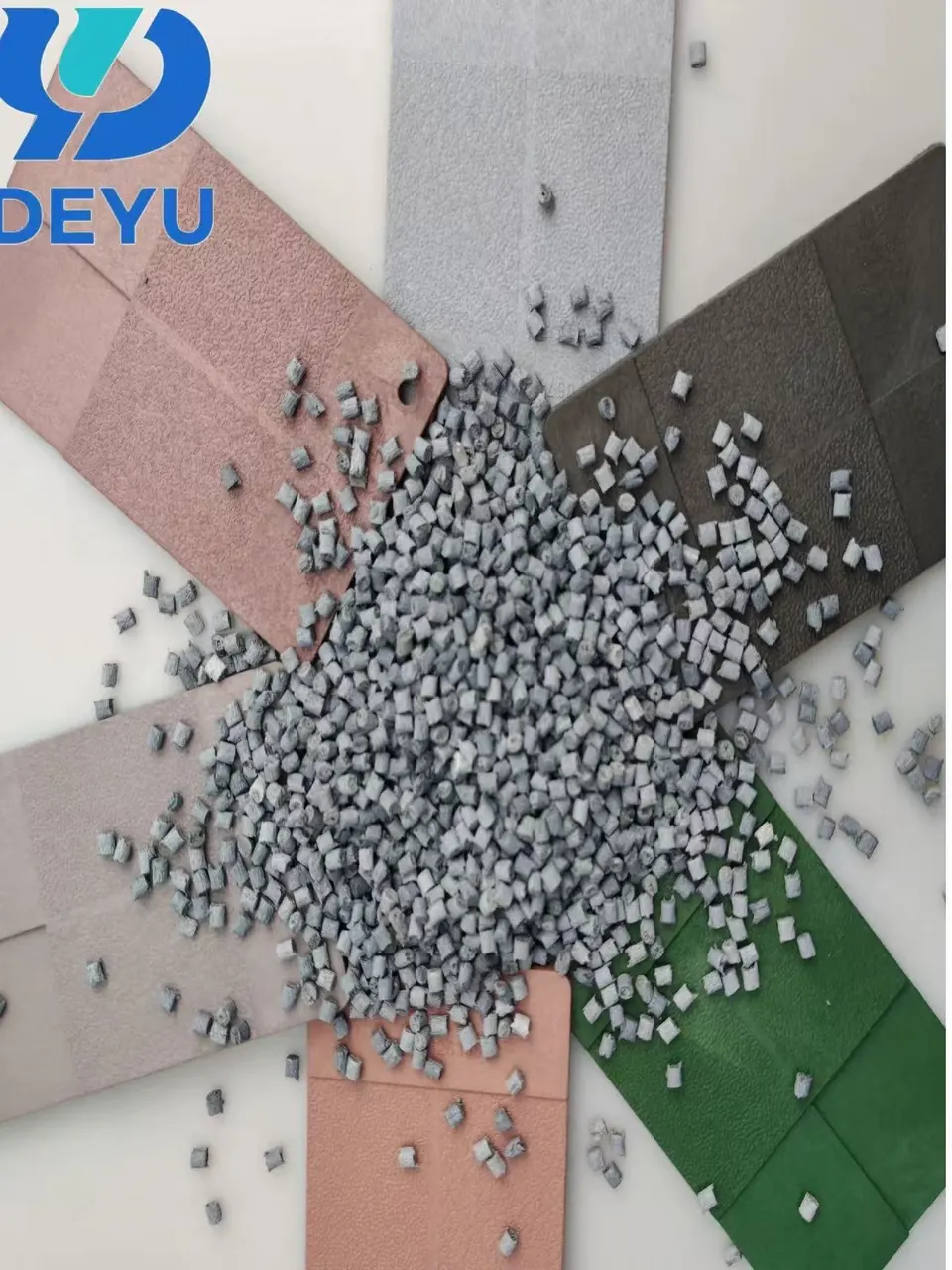 Colored carbon fiber composite material samples with gray conductive pellets on pink, gray, black and green molded sheets